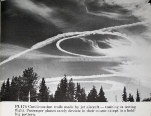 1977 Michigan – a single persistent contrail cuts the sky, through some rippled clouds.